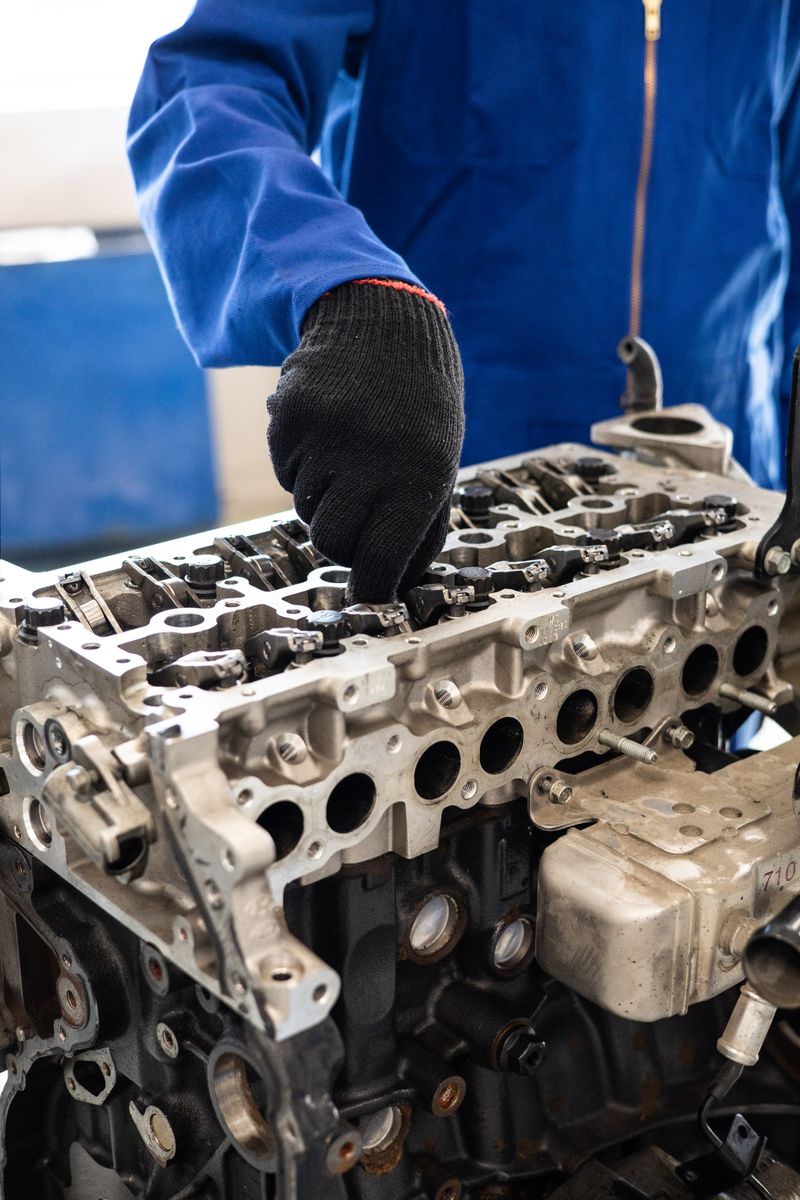 Mechanik v montérkách pracuje na hlavě motoru