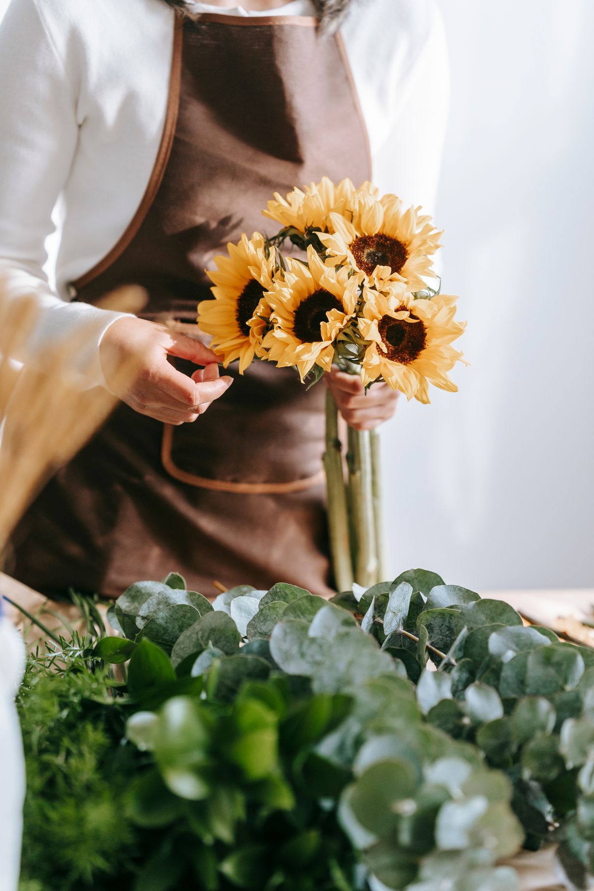 Floristka drží kytici slunečnic